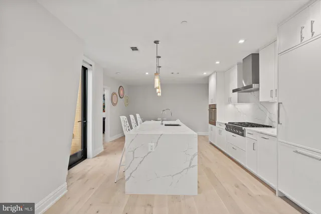 a large white kitchen with cabinets stove top oven and sink