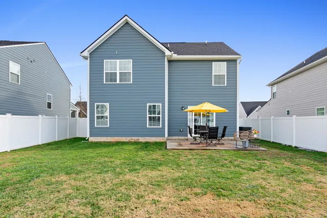 a view of a house with a yard and furniture