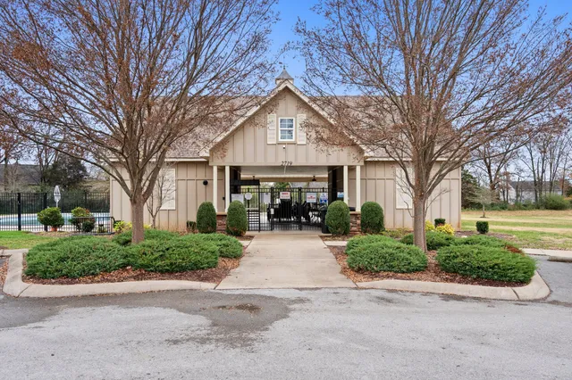 a front view of a house with garden and trees