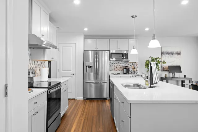 a kitchen with a sink stainless steel appliances and white cabinets