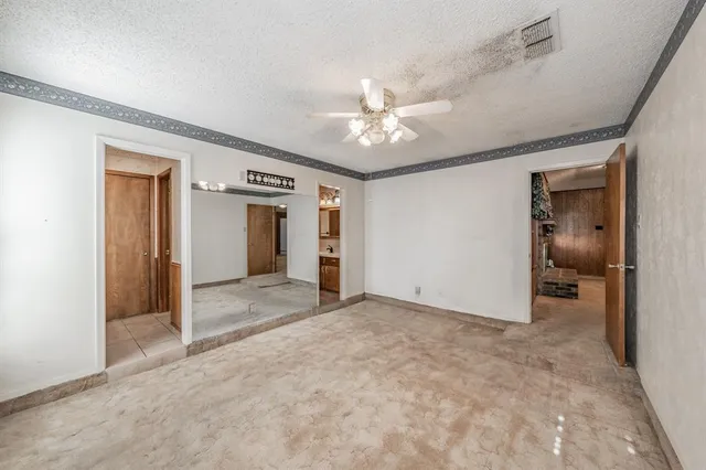 a view of a room with a stylish ceiling fan and entryway