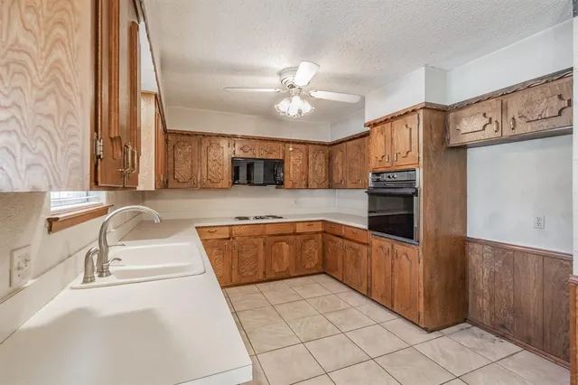 a kitchen with stainless steel appliances granite countertop a sink and a refrigerator