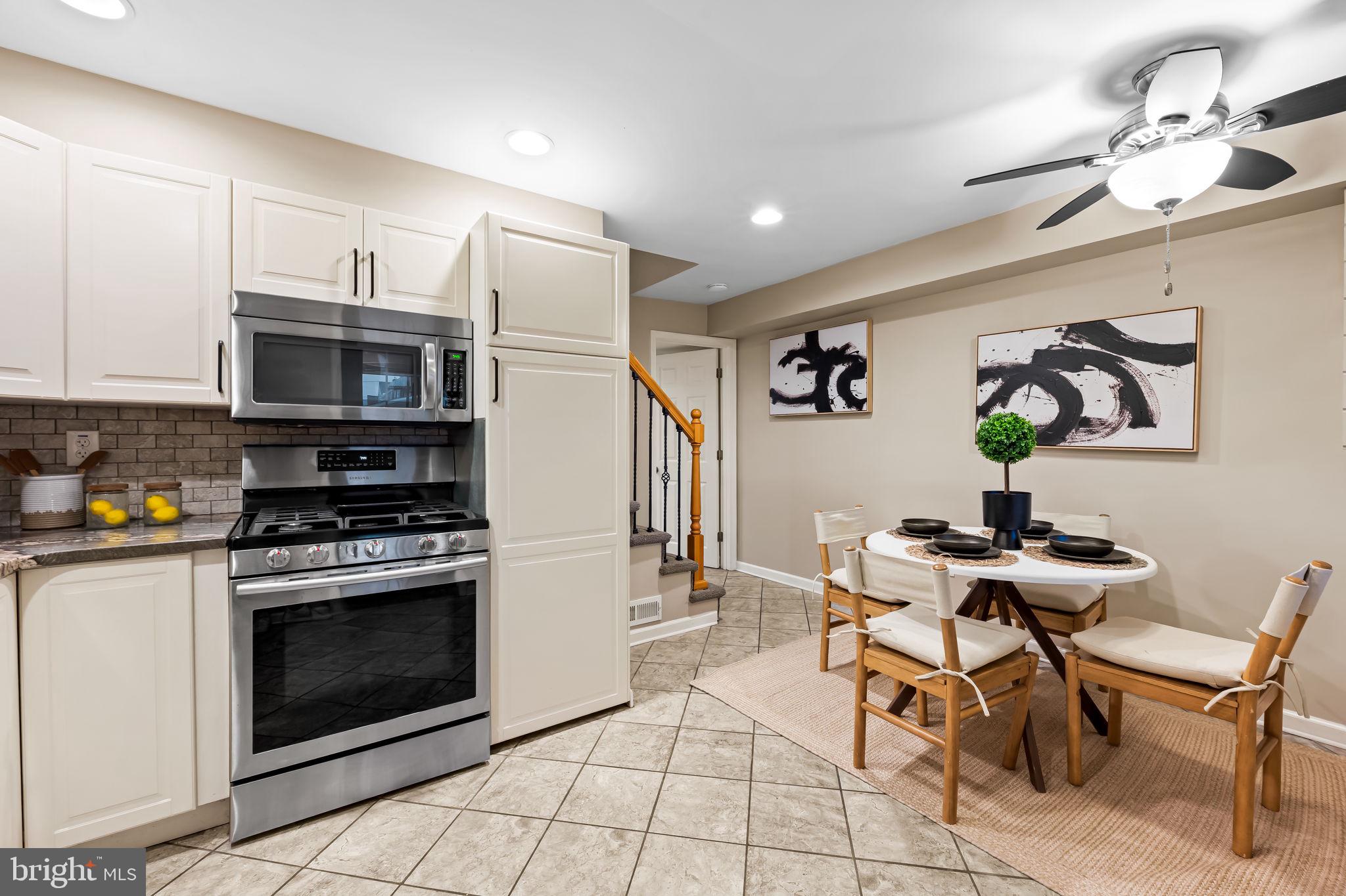 1817 Dunmere Road Baltimore, MD 21222 - Photo 11 of 27 a kitchen with stainless steel appliances a stove a sink cabinets and a dining table