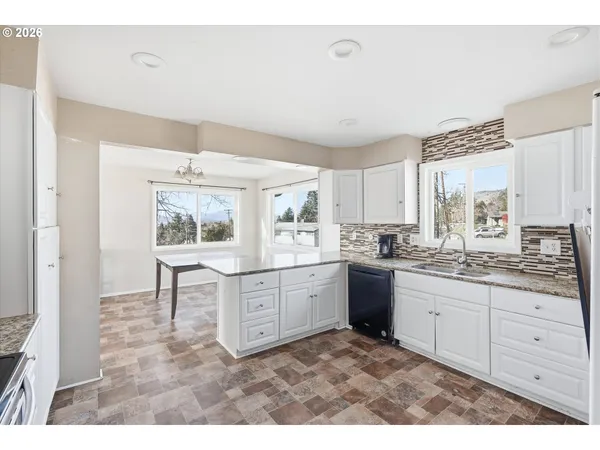 a kitchen with sink stove and white cabinets
