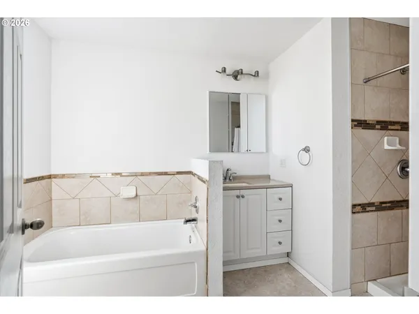 a bathroom with a tub sink and mirror