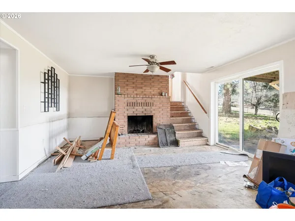 a living room with furniture a fireplace and a floor to ceiling window
