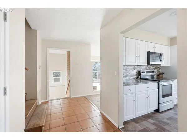a view of a kitchen with white cabinets