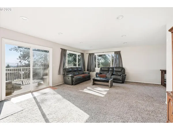 a living room with furniture and a floor to ceiling window