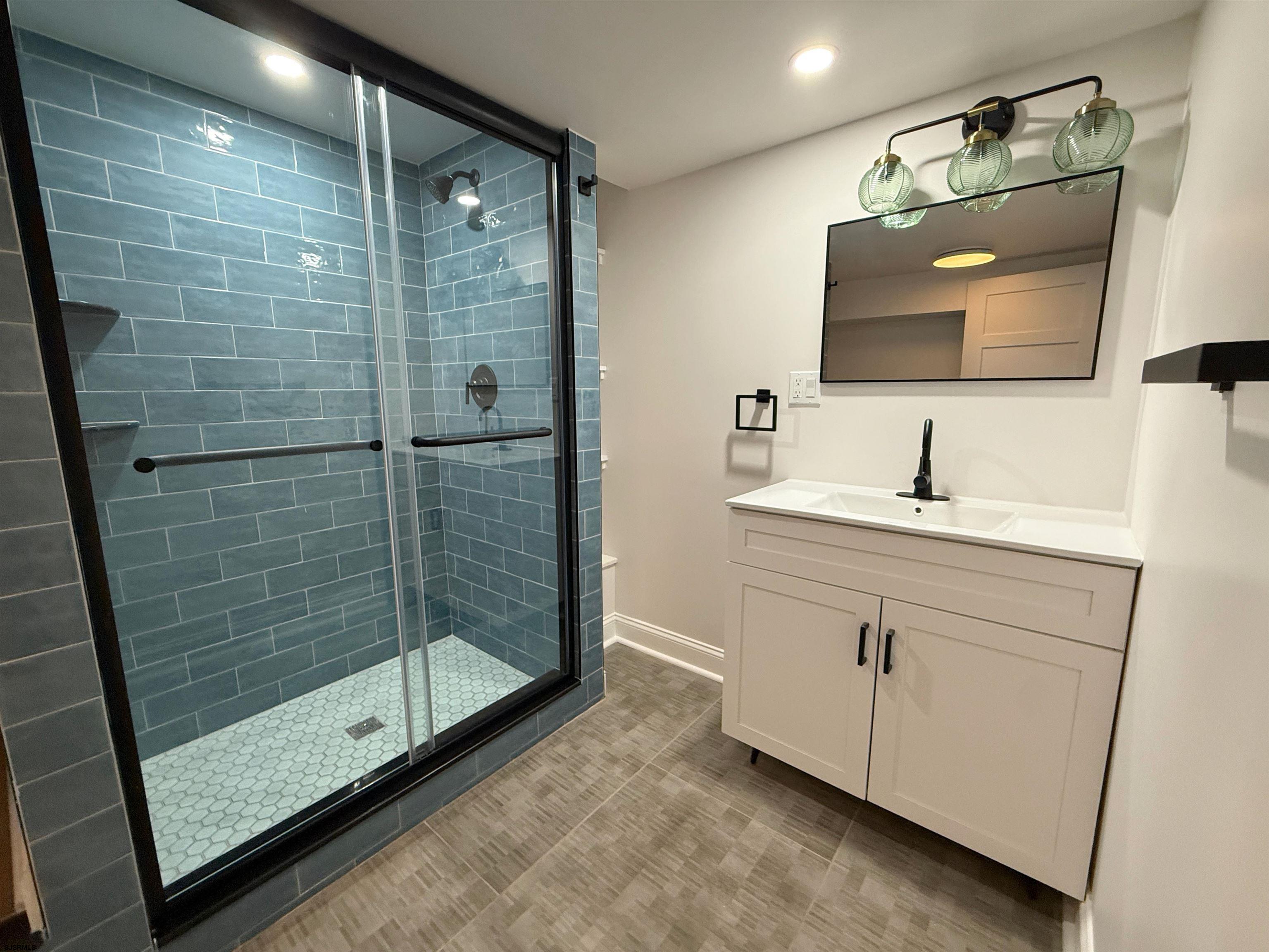 102 South Raleigh Avenue, Unit B Atlantic City, NJ 08401 - Photo 14 of 18 a bathroom with a shower sink and mirror