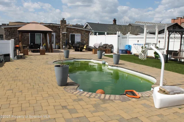 a swimming pool with outdoor seating and yard