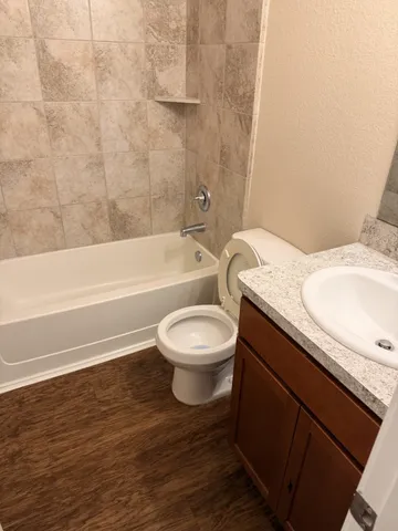 a bathroom with a granite countertop toilet a sink and bathtub