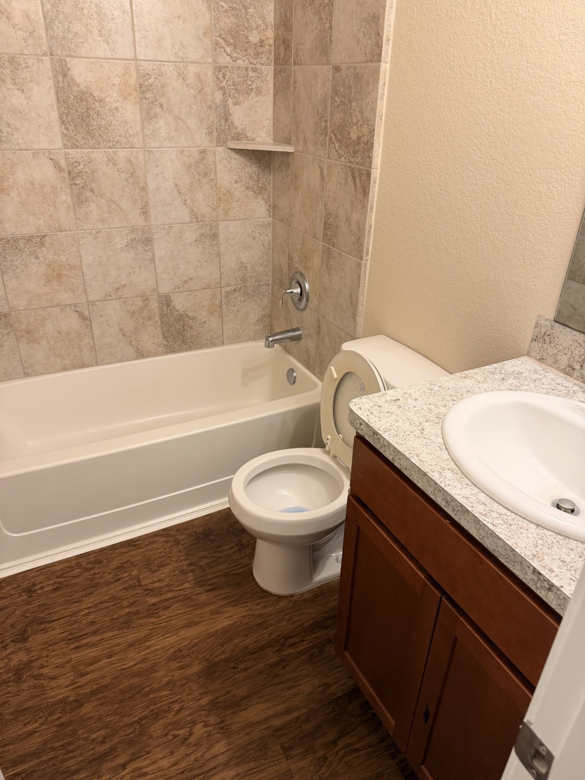 12402 Ridgecrest Drive Willis, TX 77318 - Photo 9 of 11 a bathroom with a granite countertop toilet a sink and bathtub