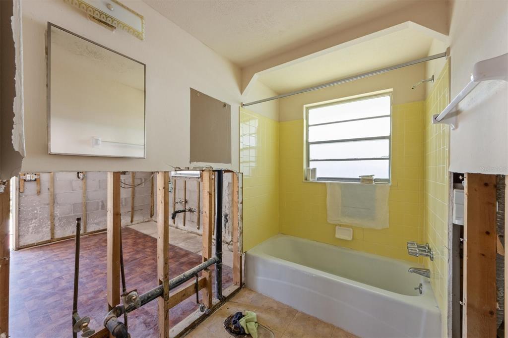 411 Alamanda Road Anna Maria, FL 34216 - Photo 17 of 41 a bathroom with a tub shower and sink