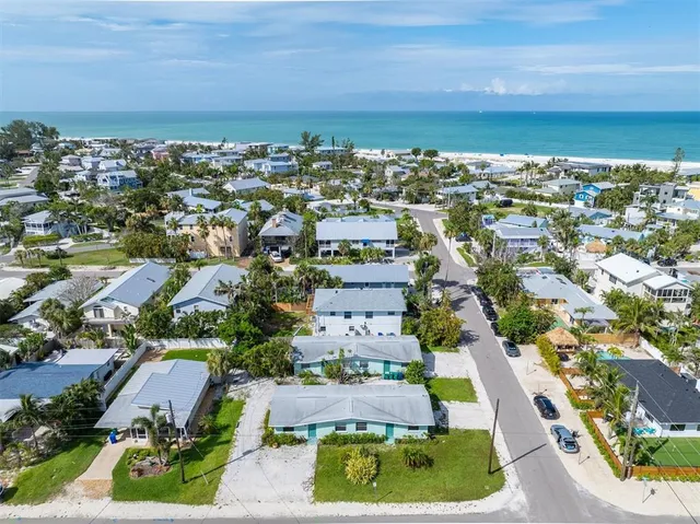 an aerial view of residential houses with outdoor space and street view