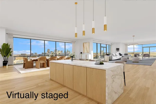 a view of a kitchen with kitchen island stainless steel appliances a sink and counter top