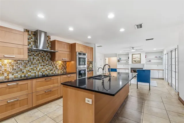 a large kitchen with stainless steel appliances lots of counter space and a sink