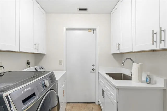 an empty room with chandelier fan and windows
