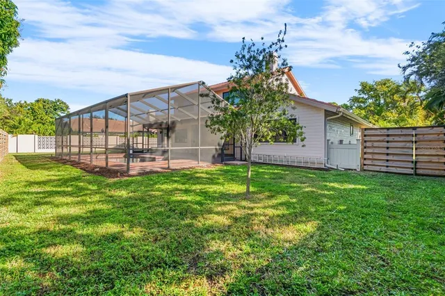 a view of a house with a yard and potted plants