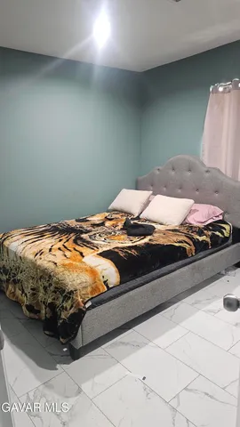 a bed sitting in a bedroom next to a lamp
