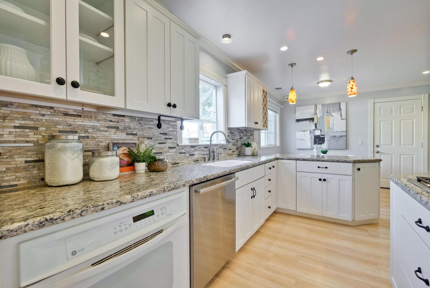 735 Widget Drive San Jose, CA 95117 - Photo 19 of 48 a kitchen with a sink dishwasher and white cabinets with wooden floor