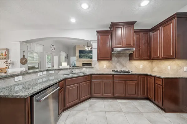 a kitchen with granite countertop stainless steel appliances a sink stove and cabinets