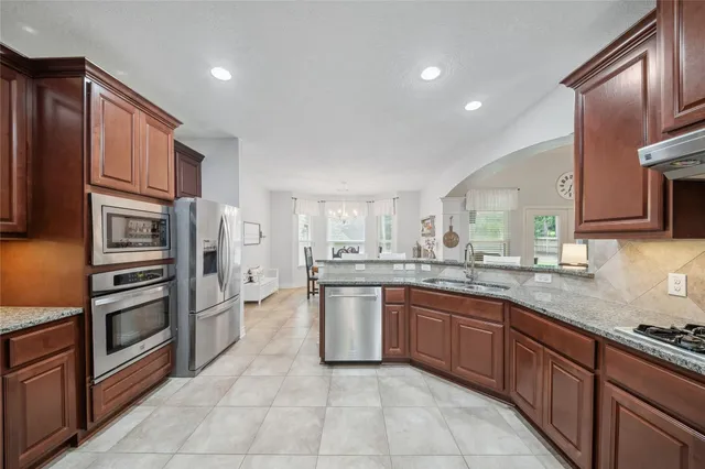 a kitchen with stainless steel appliances granite countertop a refrigerator and a sink