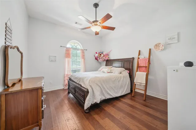 a bedroom with a bed and a flat tv screen on dresser