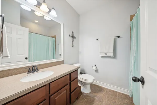 a bathroom with a granite countertop sink a toilet and a mirror