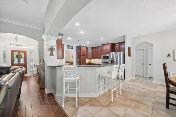 a kitchen with white cabinets and chairs