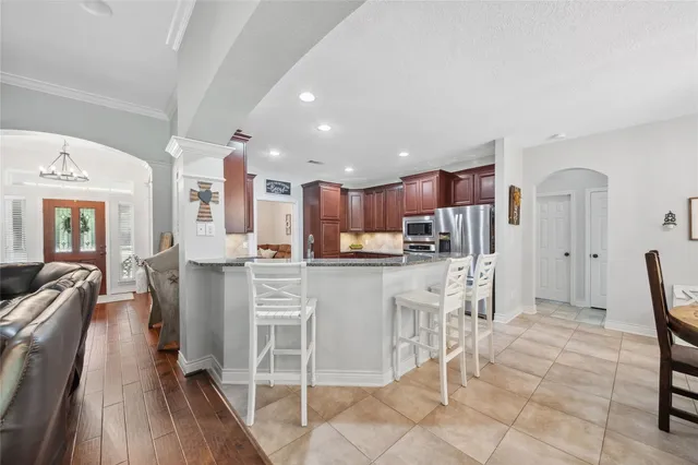 a kitchen with white cabinets and chairs