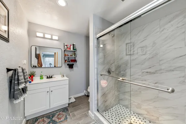 a bathroom with a sink mirror and shower