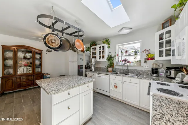 a kitchen with a sink dishwasher and a stove with wooden floor