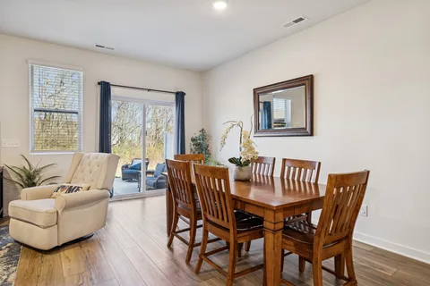 a living room with furniture kitchen view and a chandelier