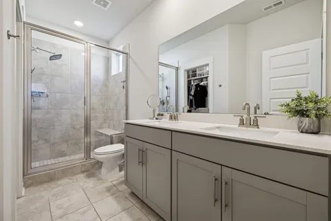 a kitchen with stainless steel appliances granite countertop a dining table chairs refrigerator and sink