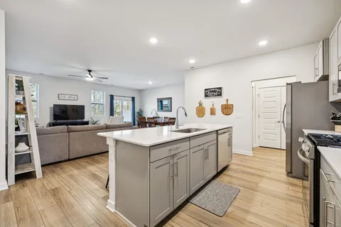 a kitchen with stainless steel appliances granite countertop a sink a stove a refrigerator and cabinets