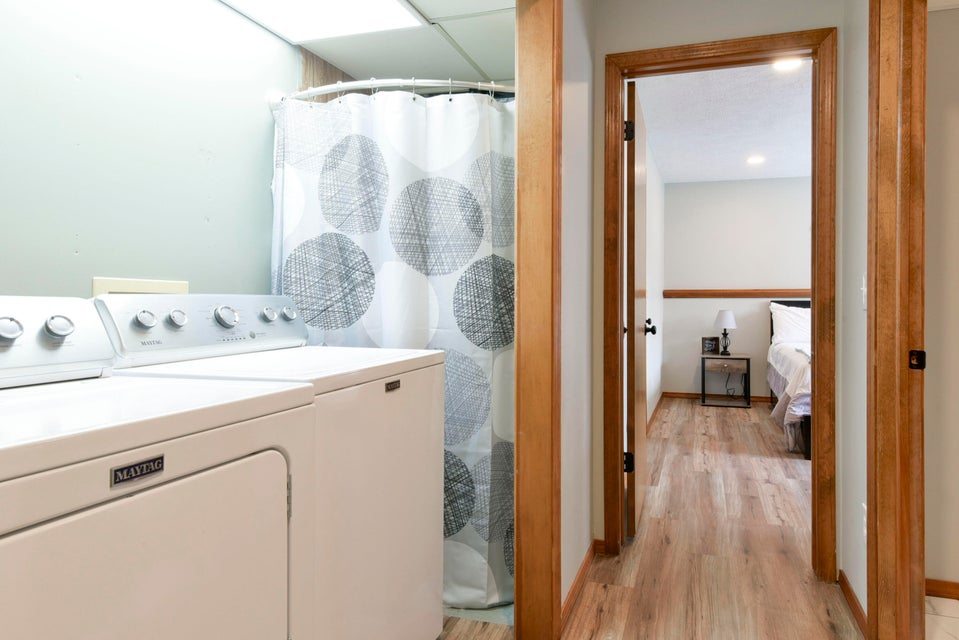 350 Campbell Point Road, Unit 2 Shell Knob, MO 65747 - Photo 12 of 17 Laundry area with a full-size washer and dryer, featuring light wood-finish flooring extending into the hallway and beyond