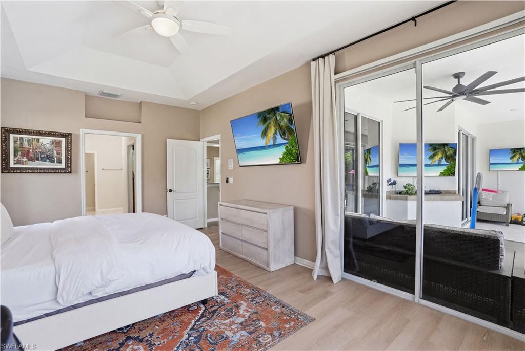 4356 Mistlethrush Lane Naples, FL 34119 - Photo 14 of 38 a bedroom with a bed and a chandelier