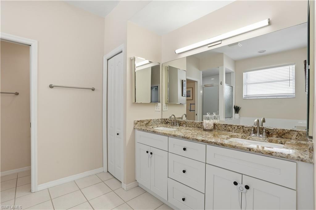 4356 Mistlethrush Lane Naples, FL 34119 - Photo 15 of 38 a bathroom with a granite countertop sink mirror and