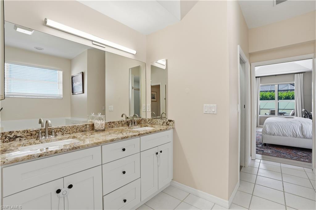 4356 Mistlethrush Lane Naples, FL 34119 - Photo 16 of 38 a en suite bathroom with a granite countertop sink and a mirror