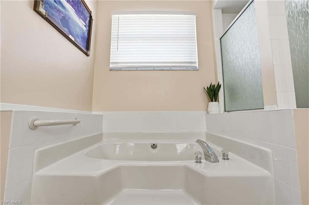4356 Mistlethrush Lane Naples, FL 34119 - Photo 17 of 38 a white bath tub sitting next to a white sink