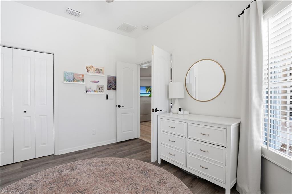 4356 Mistlethrush Lane Naples, FL 34119 - Photo 19 of 38 a bedroom with a baby bed and a dresser