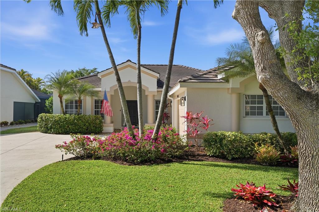 4356 Mistlethrush Lane Naples, FL 34119 - Photo 2 of 38 a front view of a house with a big yard and potted plants