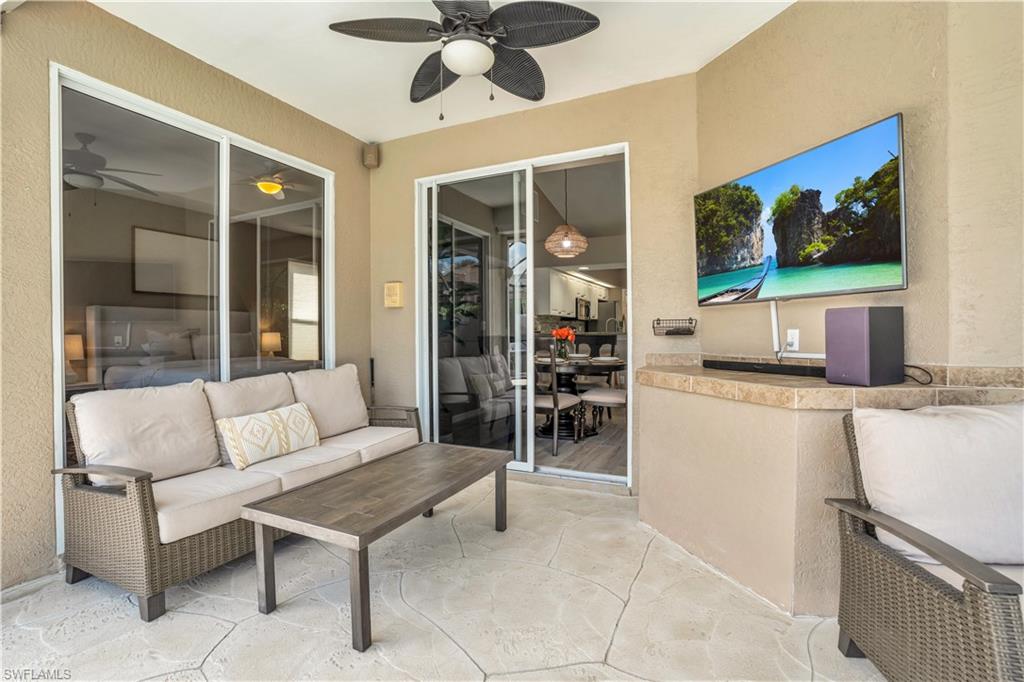 4356 Mistlethrush Lane Naples, FL 34119 - Photo 29 of 38 a living room with furniture a flat screen tv and a large window