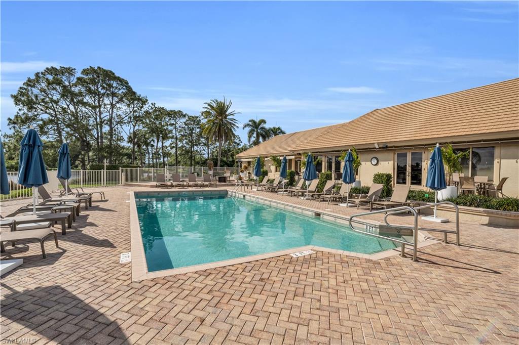 4356 Mistlethrush Lane Naples, FL 34119 - Photo 36 of 38 a view of a swimming pool with chairs in patio