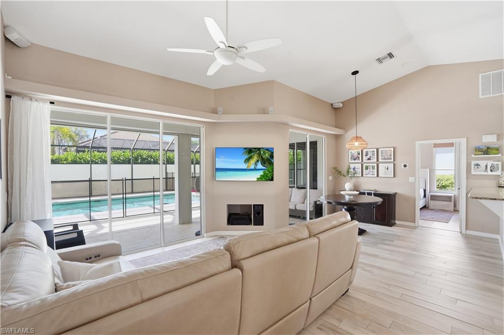 4356 Mistlethrush Lane Naples, FL 34119 - Photo 5 of 38 a living room with fireplace furniture and a large window