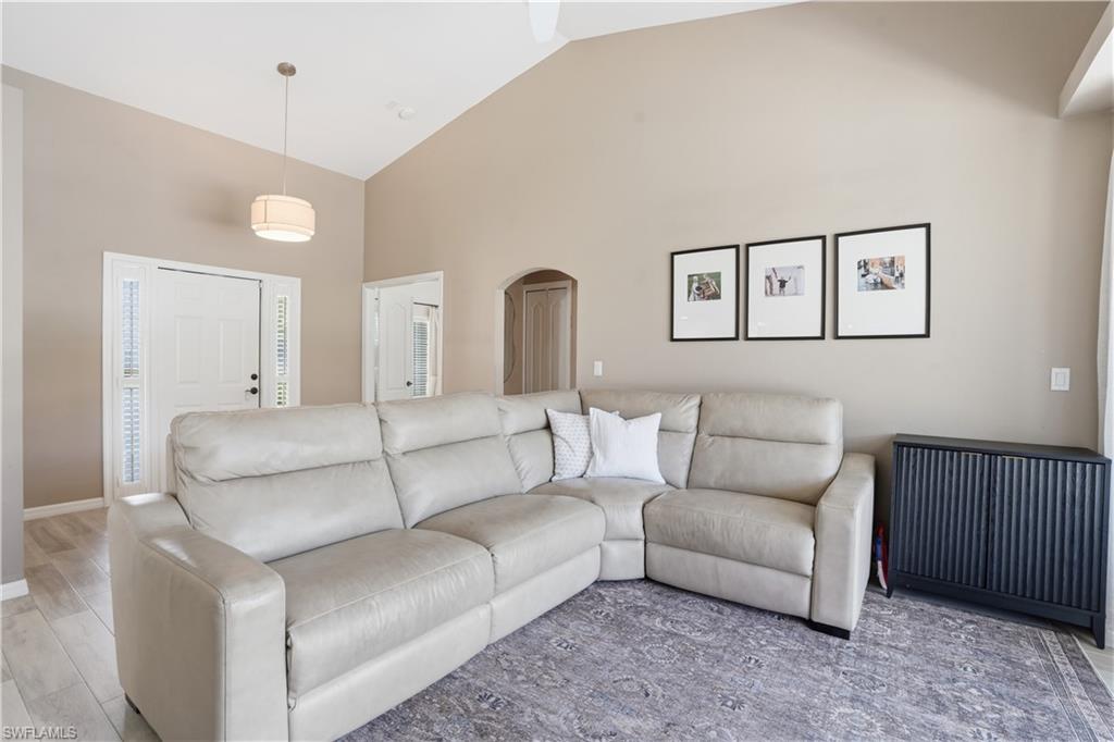 4356 Mistlethrush Lane Naples, FL 34119 - Photo 7 of 38 a living room with furniture a bed and painting on the wall