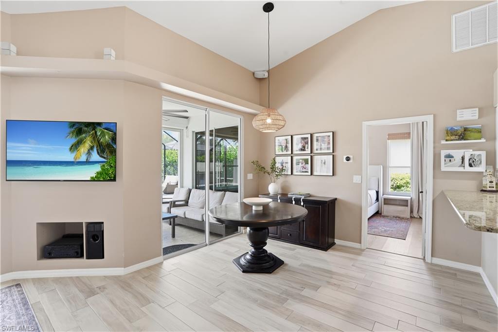 4356 Mistlethrush Lane Naples, FL 34119 - Photo 8 of 38 a living room with fireplace furniture and a wooden floor