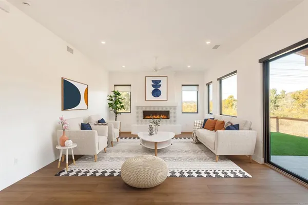 a living room with fireplace furniture and a large window