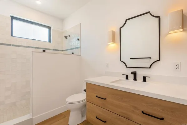 a bathroom with a toilet sink vanity and mirror