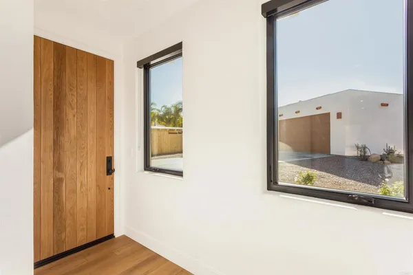 a view of a hallway with wooden floor and entryway
